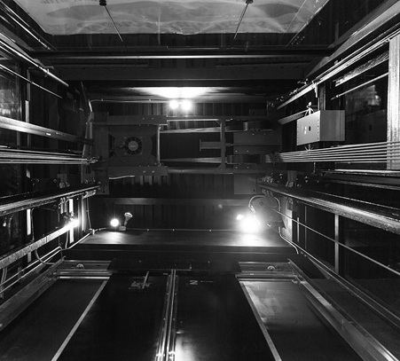 a black and white photo of a long row of ovens